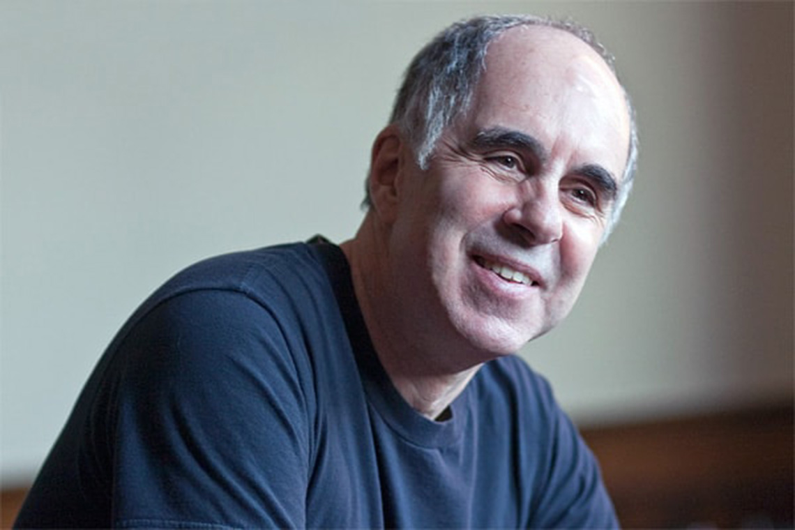 A man in a blue shirt smiles at the camera