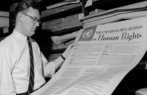 Person looking at a newspaper with headline for the UN declaration of human rights