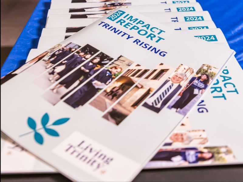On display on a table, Copies of Impact Report 2023-2024-TrinityRising