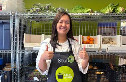 Fiona Wan is wearing an apron, smiling at the camera, giving the thumbs up
