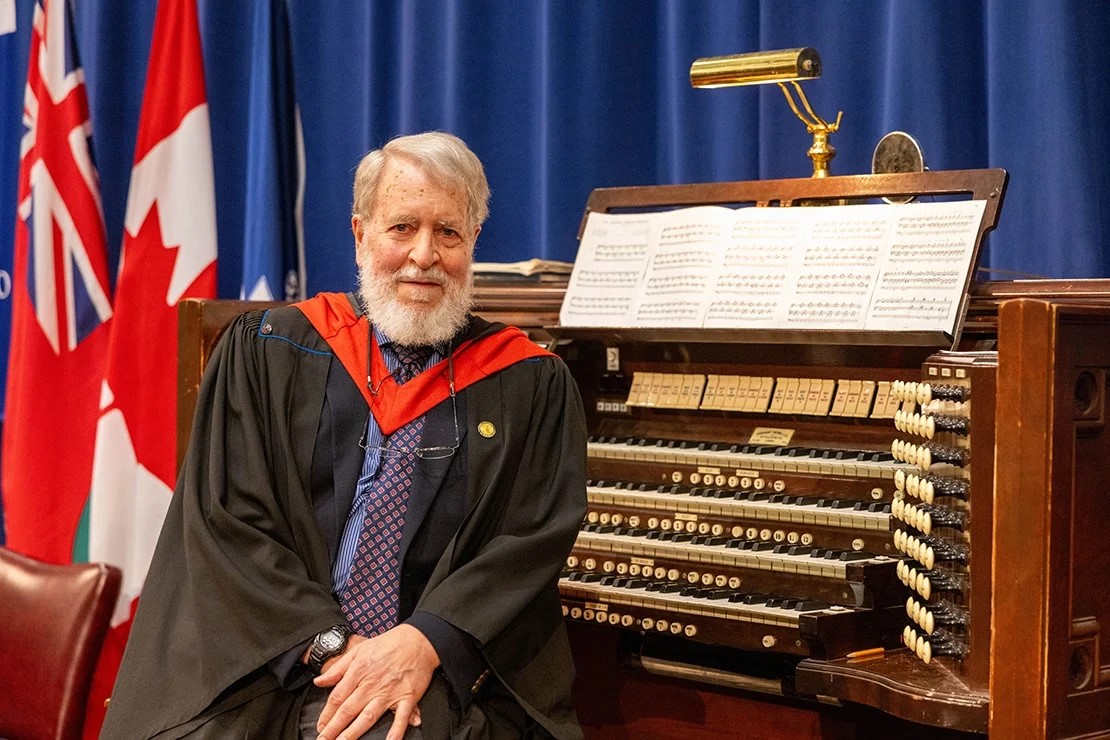 John Tuttle sits in front of an organ at Convocation Hall