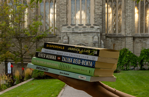 Person holding 5 books as part of the Trinity Reads campaign