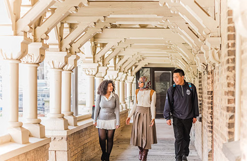 Students walk down a covered walkway on the University of Toronto campus