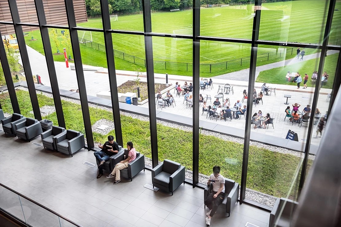 Photo of students sitting inside and outside of a building at U of T