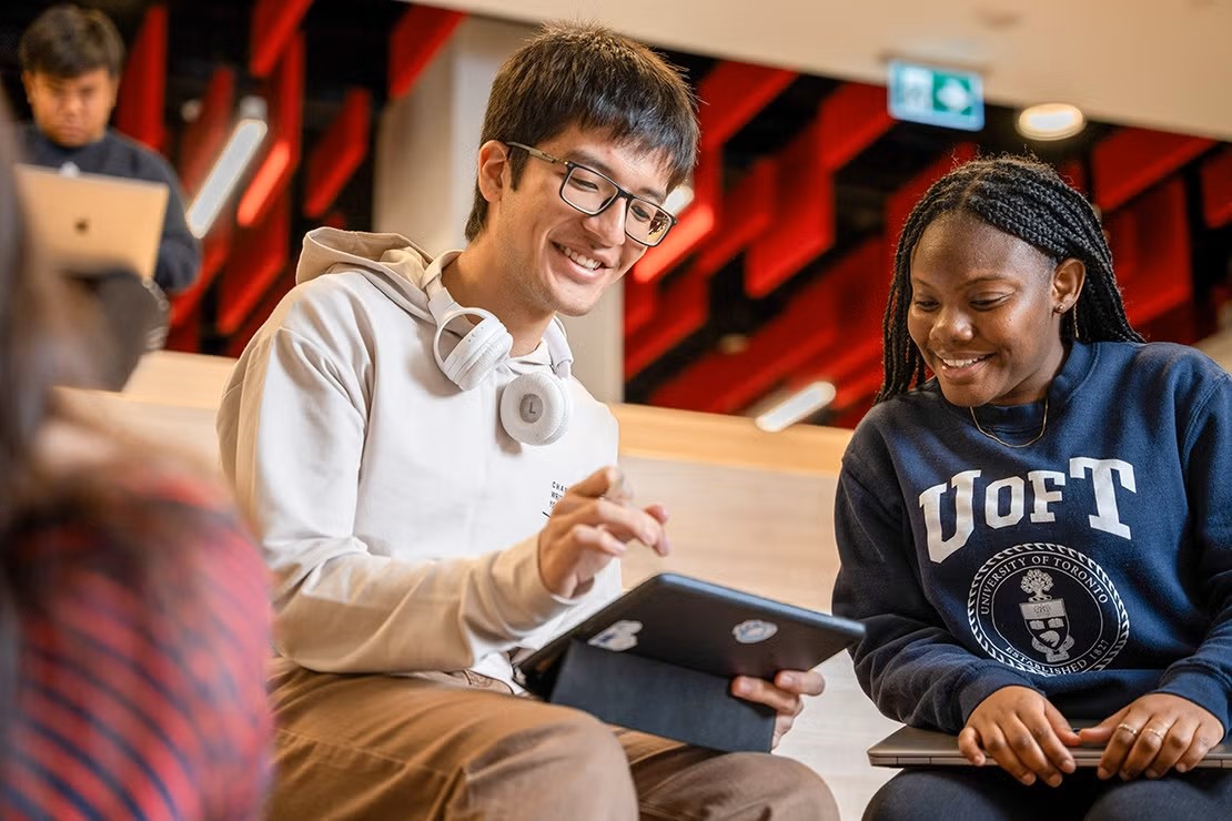 Two UofT students look at a laptop