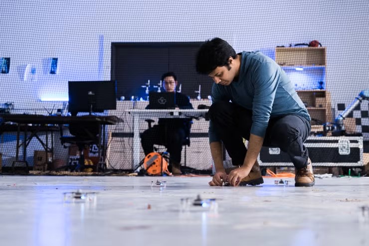 Person setting up drones on a lab floor