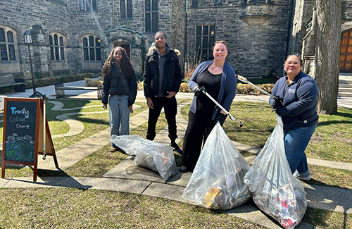 Students and staff pose with garbage bags