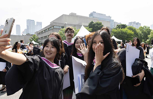 A group of students wearing graduation caps & gowns