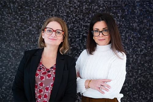 Jen Gommerman and Valeria Ramaglia pose against a hedge background