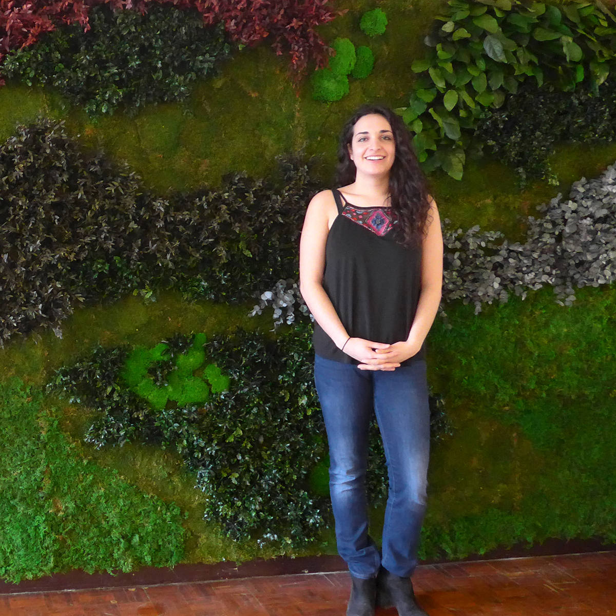 Danielle Pal stands in front of the green wall in The Buttery